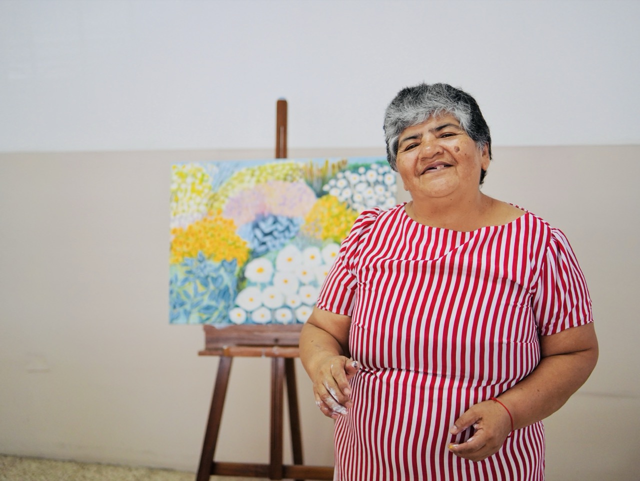 Artista del Centro de Día IDEA junto a su obra